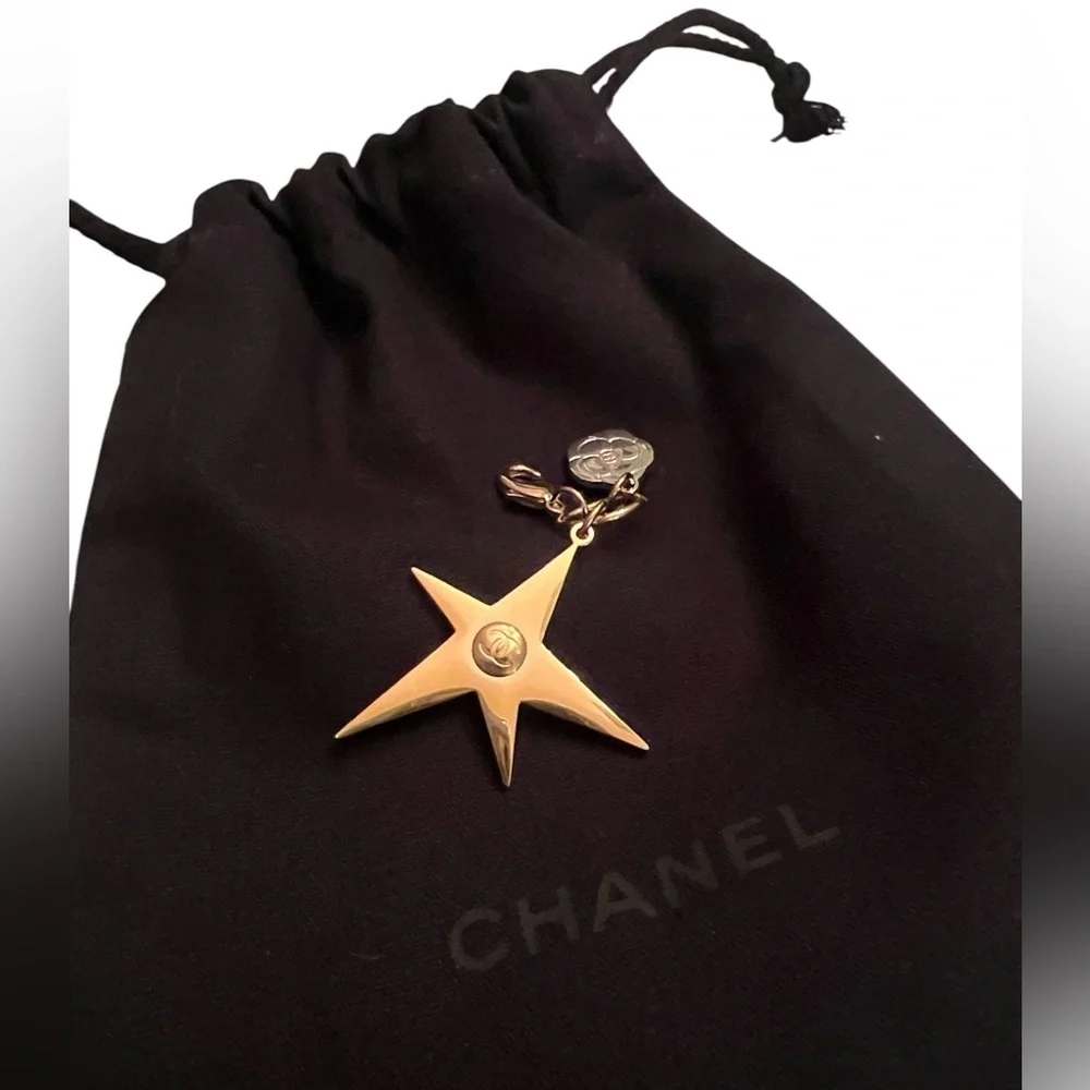CHANEL Gold Star & small Camellia key Charm with black drawstring pouch.